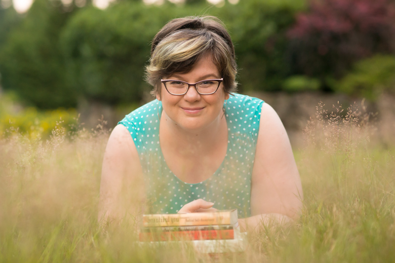 Body Positive and Fat Positive Business Branding Sessions for Health at Every Size (HAES) Providers, Ecommerce, Entrepreneurs, Therapists, Nutritionists and Dietitians
Meredith Noble, a fat white woman of Canadian heritage, lies on her stomach in a grassy field with her torso and face shown and a stack of HAES and body image books in front of her on the ground. She is wearing glasses and a blue polka-dotted sleeveless dress.